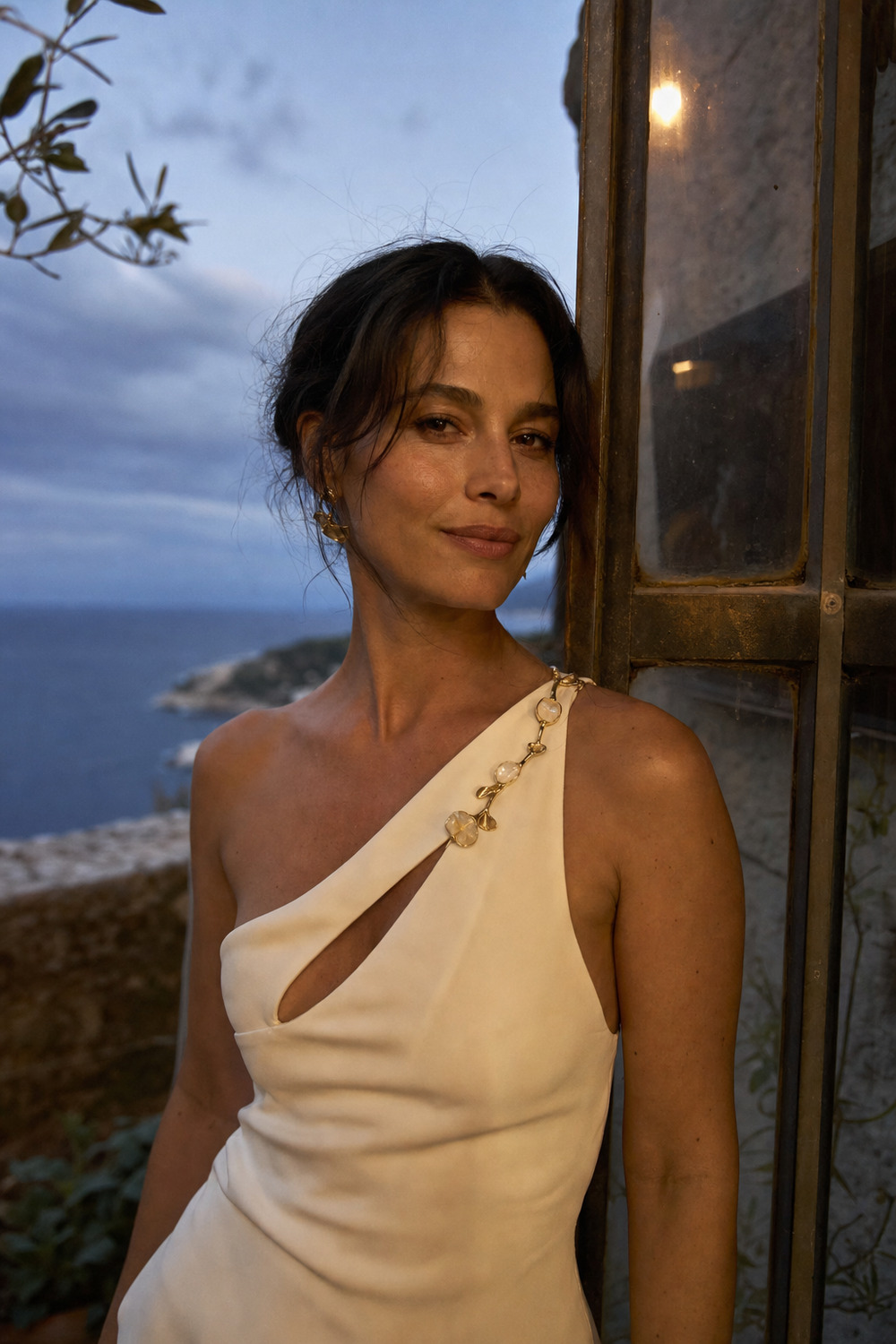 An ivory evening look fastened with delicate botanical gold jewelry.
